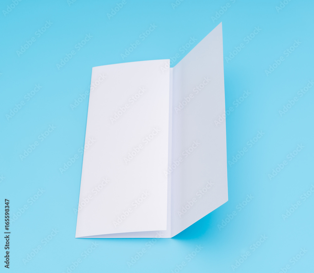 Trifold white template paper on blue background . Trifold white template paper on blue background .