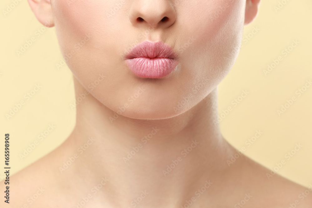 Obraz premium Closeup view of beautiful young woman with natural lips makeup on color background