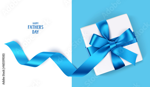 Decorative gift box with blue bow and long ribbon. Happy Father's Day text. Top view photo
