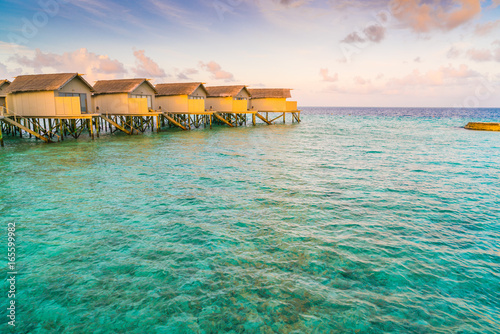 Fototapeta Naklejka Na Ścianę i Meble -  Beautiful water villas in tropical Maldives island at the sunrise time .