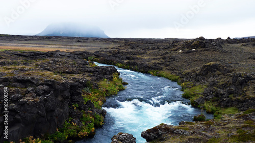 rei  ender Fluss in karger Lavalandschaft mit Blick auf Vulkan Hekla in Island