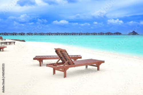 Sun loungers on beach in summer day