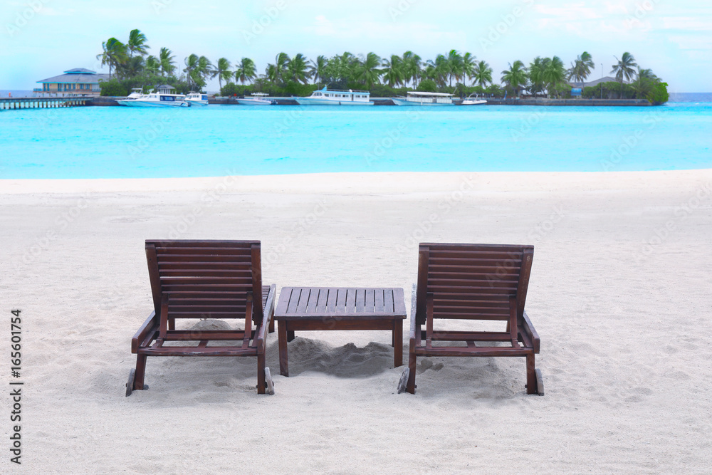 Wooden sun loungers on beach at sea resort