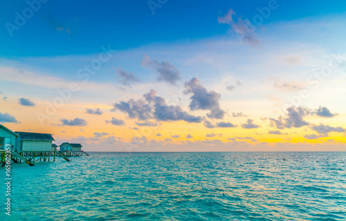 Beautiful water villas in tropical Maldives island at the sunset time . © jannoon028