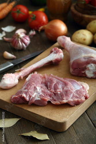 carne cruda coscia disossata di pollo o tacchino sfondo tavolo di cucina rustico
