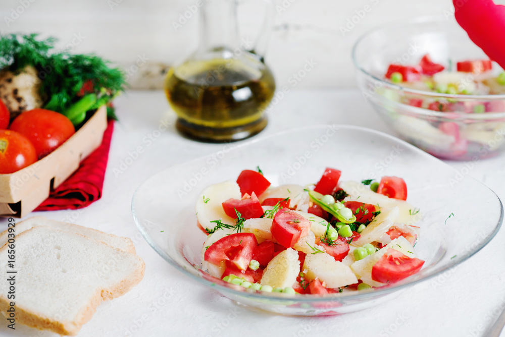 Tasty and healthy breakfast, lunch or dinner, potato salad with tomato, green peas, olive oil, spices and white toast on a light background 
