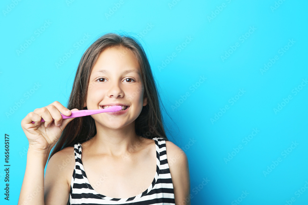 Portrait of beautiful girl with toothbrush on blue background Portrait of beautiful girl with toothbrush on blue background