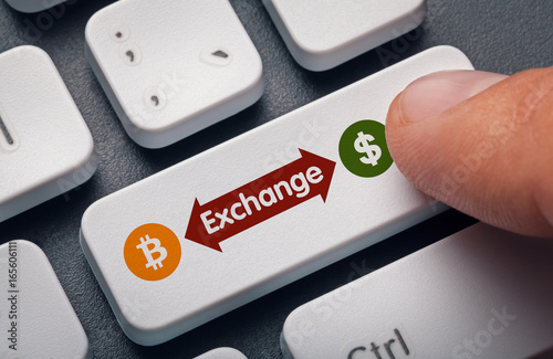 finger pressing computer key with bitcoin, dollar symbol and exchange word. crypto mining concept photo