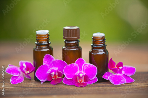 Essence of orchid flowers on table in beautiful glass bottle