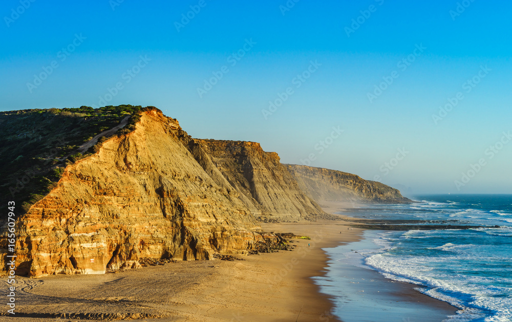 Vivid yellow sand and rocks on coastline, Portugal