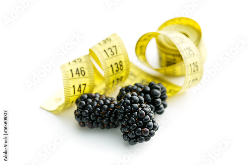 Tasty ripe blackberries and measuring tape. photo