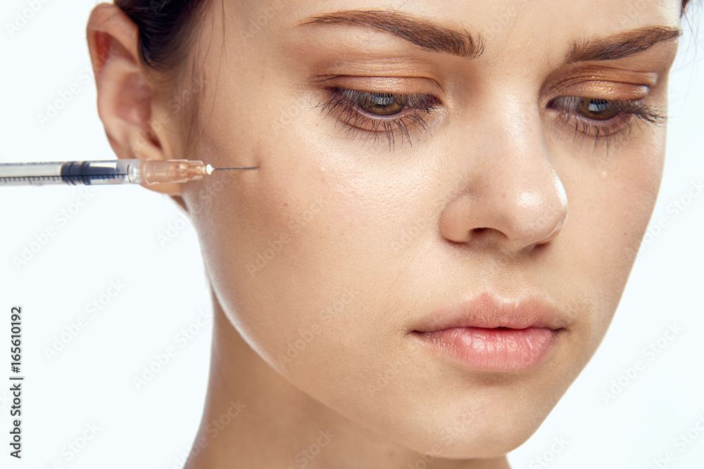 Beautiful young woman on white isolated background holds a syringe, medicine, plastic surgery