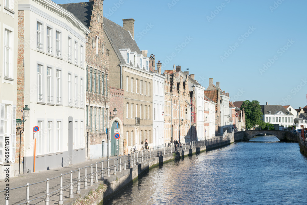 Canal and colorful traditional houses against blue sky in Brugge, Belgium