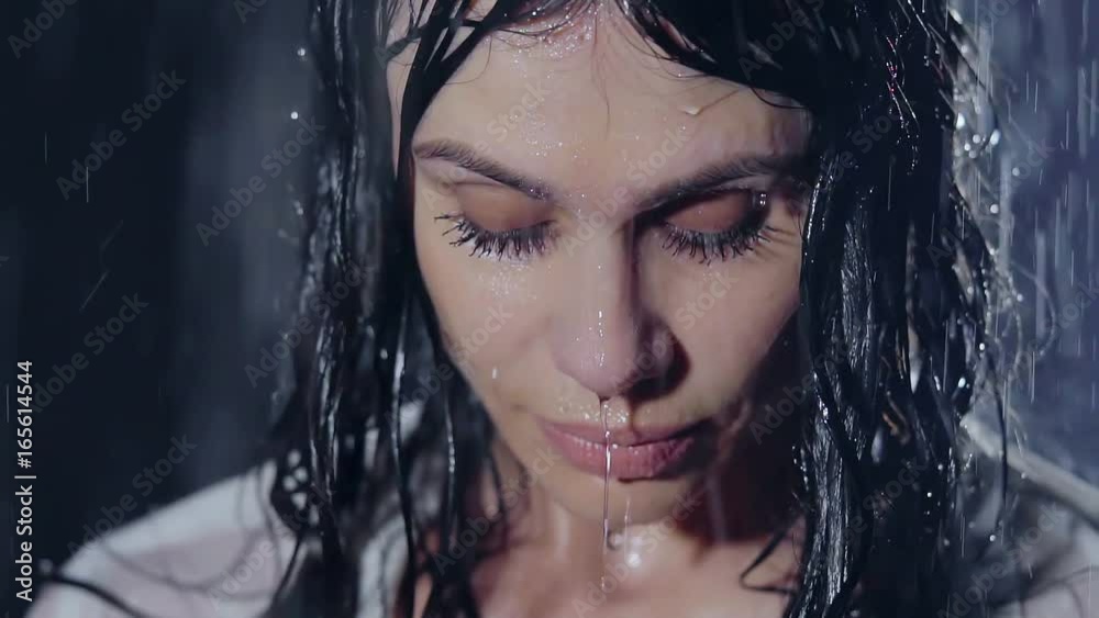 close-up. portrait of a girl with glued eyelashes and lips inflated, she is graceful and beautiful. in the rain at night close-up. portrait of a girl with glued eyelashes and lips inflated, she is graceful and beautiful. in the rain at night