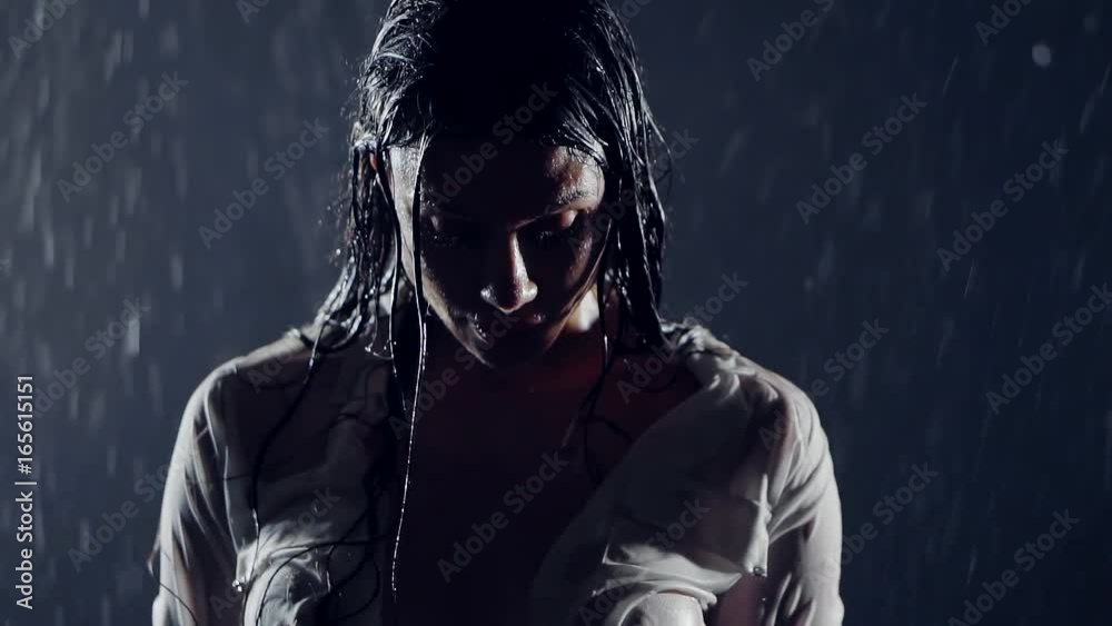 wet in the rain in the night sad, middle-aged woman. insanely sexy body covered with a wet shirt from under cloth visible erect hard nipples big silicone breast