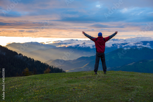 Happy traveler with open arms admiring fantastic sunset