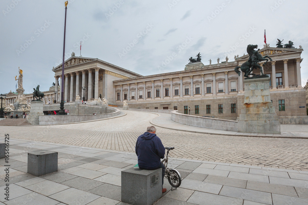 Tourists near the building of the Austrian Parliament on a cloudy summer day. Blurred Faces, Unrecognizable Faces. in Vienna, Austria.