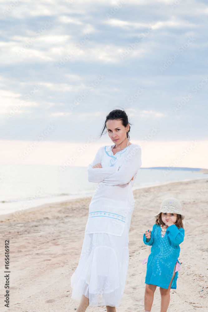 family mother and daughter on a sandy beach under a cloudy sky family mother and daughter on a sandy beach under a cloudy sky