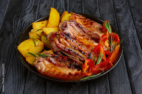 Fried meat on rib with potato and tomato