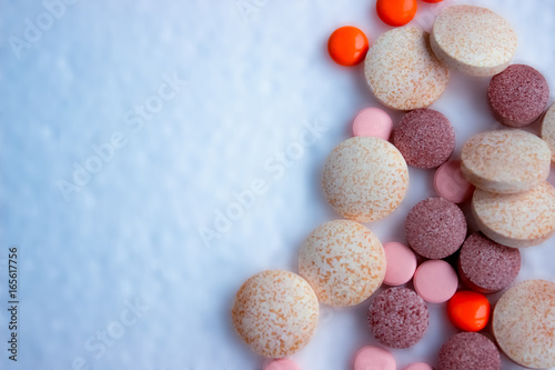 Assorted colorful pills, tablets on the blurred background. Medicine mock up. Health care concept, vitamins.