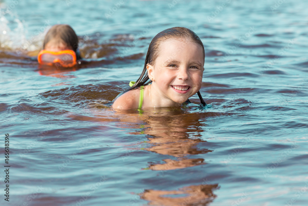 Sweet happy little girl bathing in the sea Sweet happy little girl bathing in the sea
