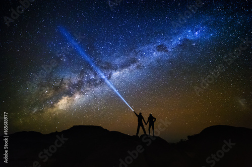 Landscape with Milky Way. Night sky with stars and silhouette of a couple on the mountain.
