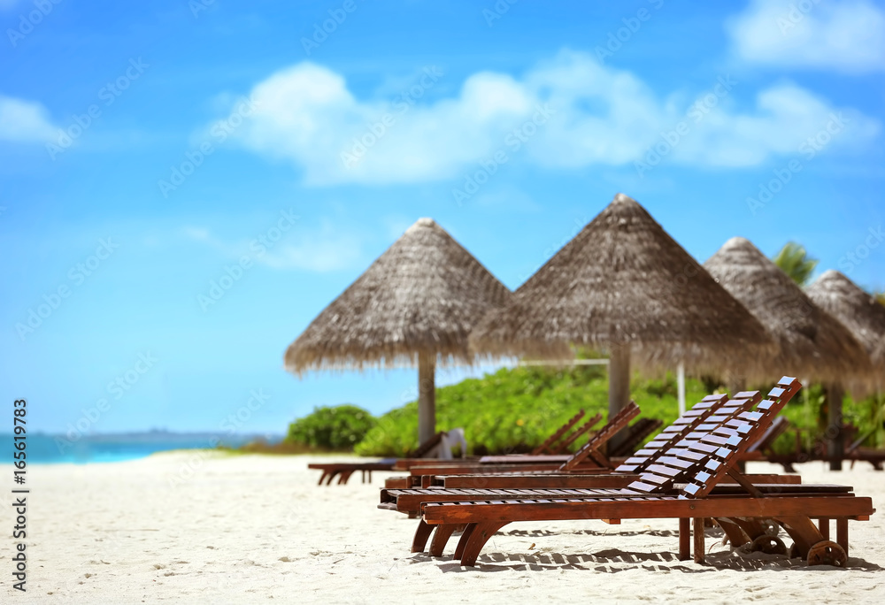 Fototapeta premium View of tropical beach with sun loungers on summer day
