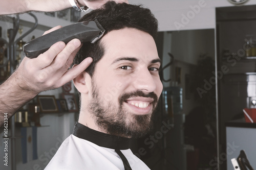 Man having a haircut with hair clippers.