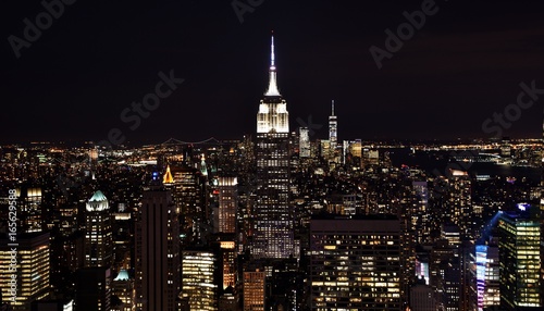 The Empire State Building, One World Trade Center, and the skyline of downtown Manhattan at night. 