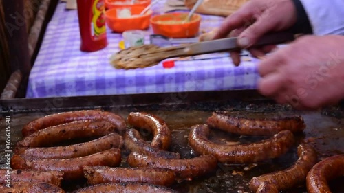 Smoking delicious sausage,turning and coating sausages on the grill,Belo Blato, Vojvodina, Serbia,12th of March, 2017.