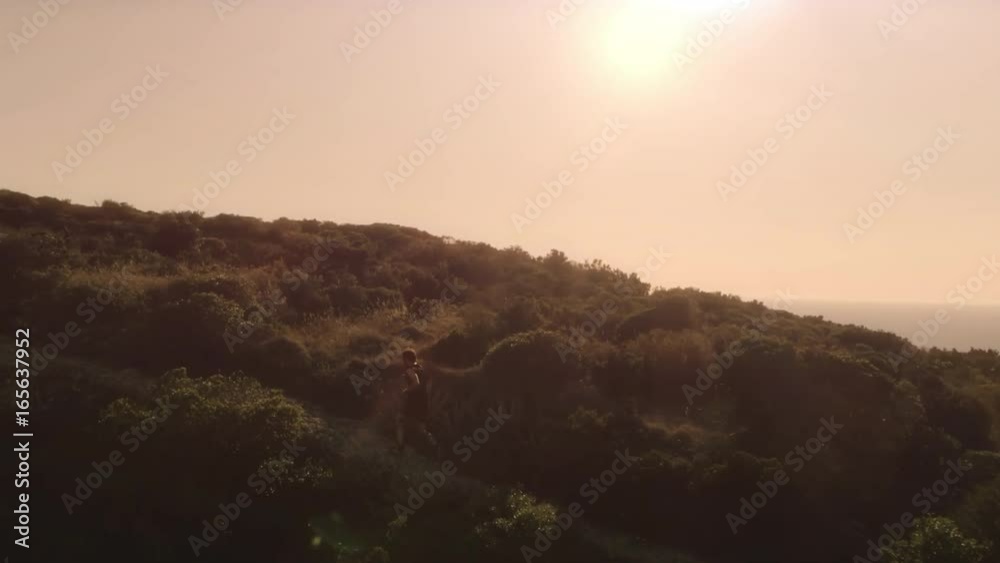 Man running on top of a mountain on an island