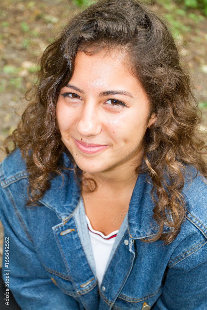 Teenage girl sitting on the grass park