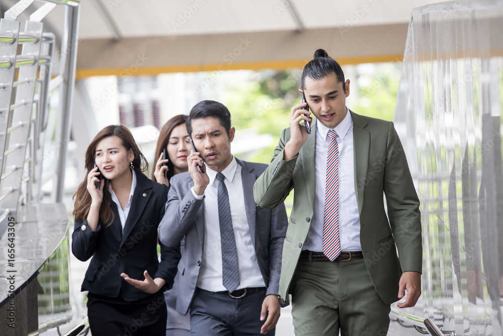  Businesspeople using smartphone for talk business project while walking. Businesspeople  working concept. Poeple with busy situation.