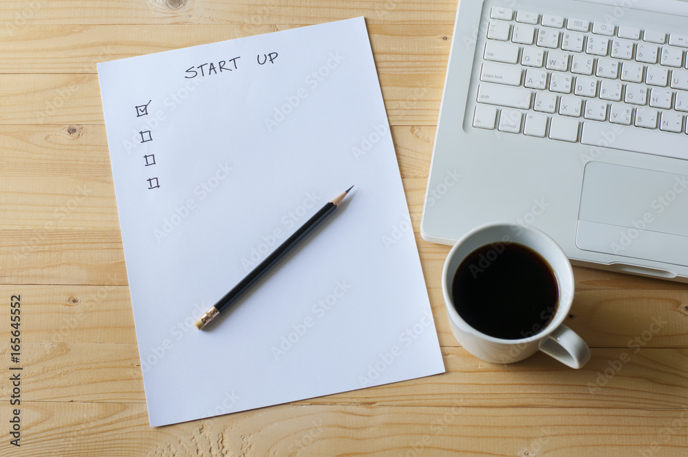 Paper check list for start up business laptop and coffee on wood table. Paper check list for start up business laptop and coffee on wood table.