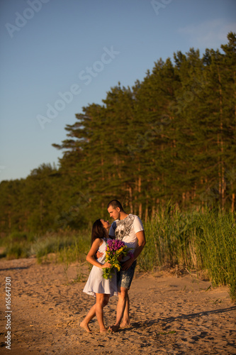 A young couple in love, on the shore of the Bay at sunset © viktoria_koks