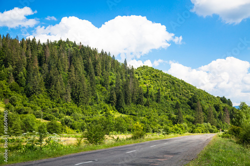 Mountain road in summer. Beautiful landscape hill forest and blue sky.