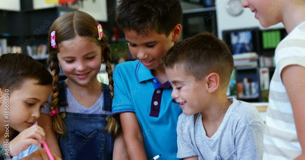 Smiling school kids using digital tablet in classroom Smiling school kids using digital tablet in classroom