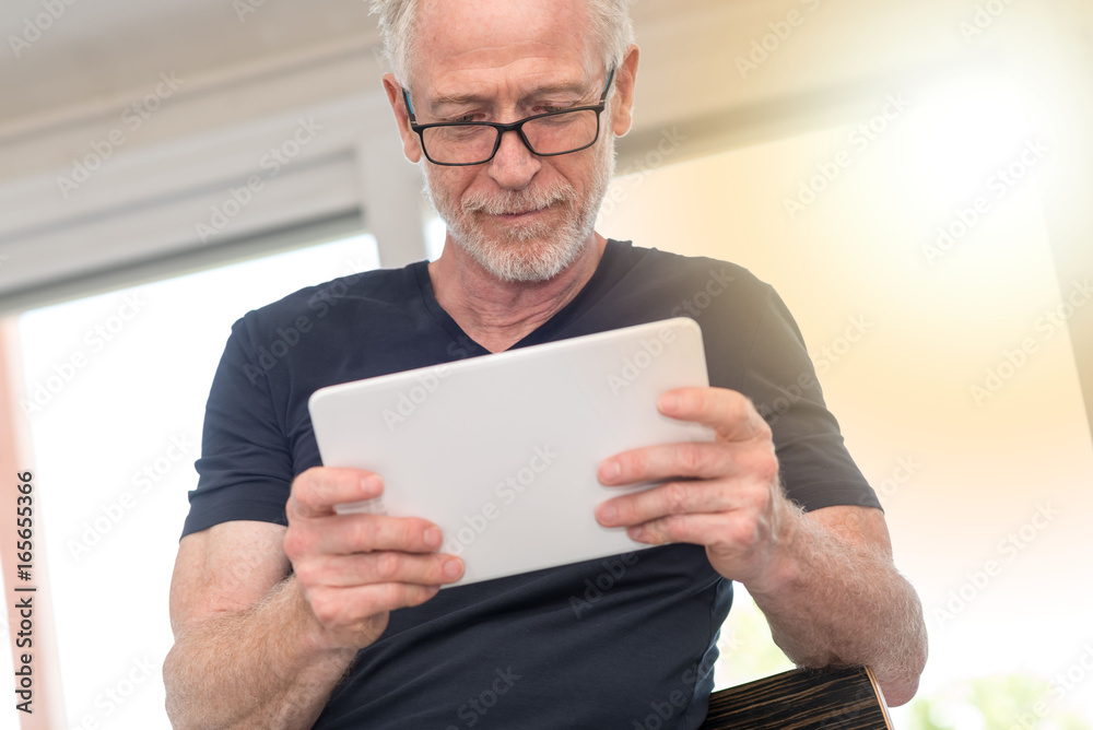 Mature man using digital tablet, light effect Mature man using digital tablet, light effect