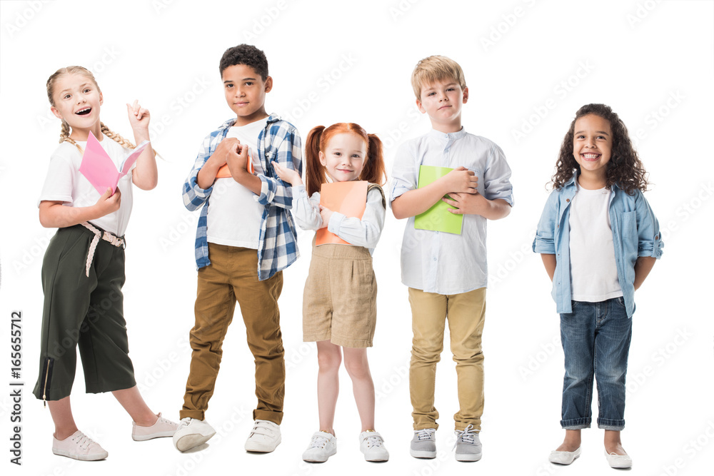 adorable multiethnic children holding textbooks and smiling at camera isolated on white