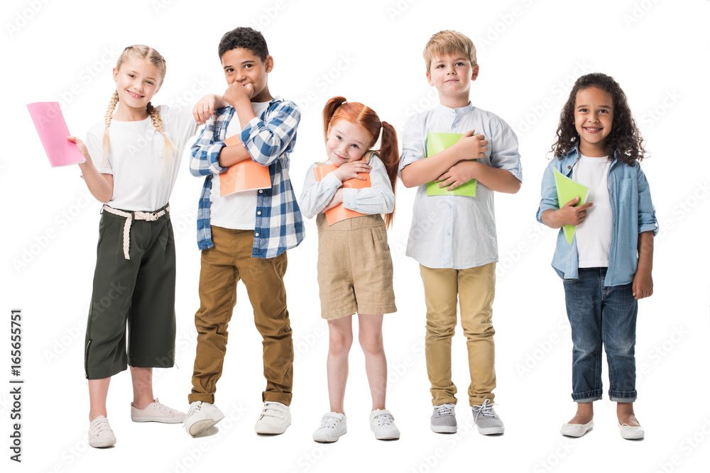 adorable multiethnic children holding textbooks and smiling at camera isolated on white adorable multiethnic children holding textbooks and smiling at camera isolated on white