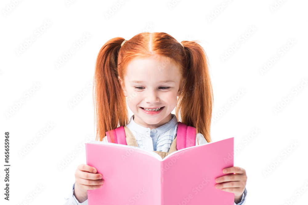 Adorable smiling schoolgirl reading textbook isolated on white Adorable smiling schoolgirl reading textbook isolated on white