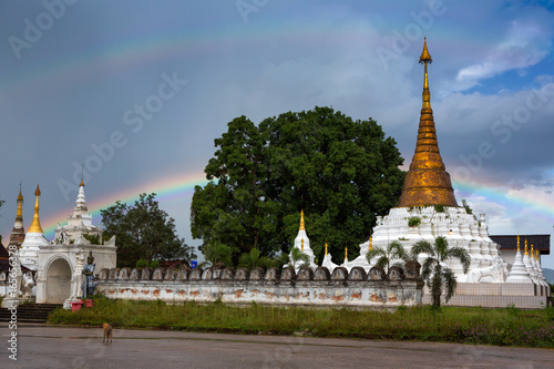 Rainbow over Pagoda, Buddhist architecture at Wat Mon Chamsin in the evening light, Lampang Province, Thailand photo