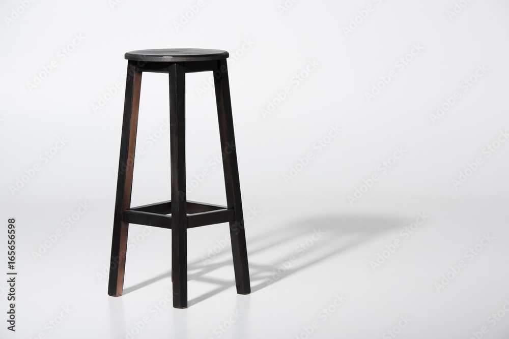 Obraz na plátně Studio shot of classic black tall wooden barstool standing on white