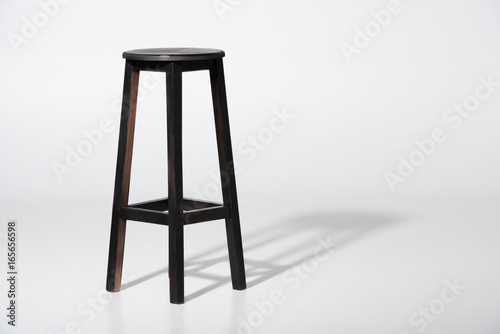 Studio shot of classic black tall wooden barstool standing on white photo