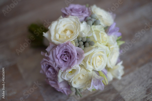 Pastel bridal round bouquet with purple and white roses. Floral arrangement ideas for the bride and bridesmaids