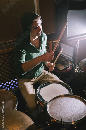 Drummer playing drums in recording studio. Rehearsal before live concert