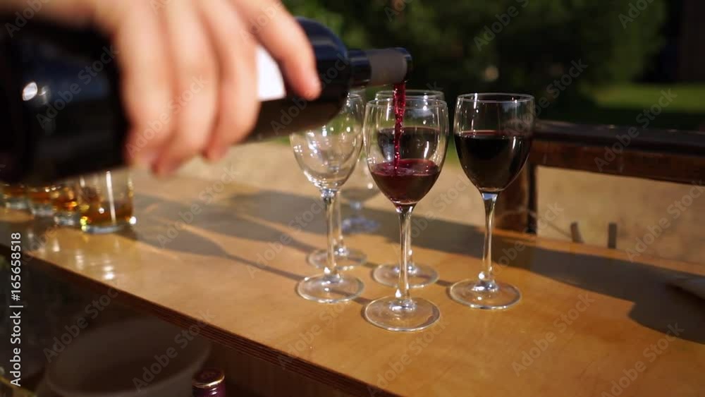 Spill the wine into the glasses standing on the counter. Spill the wine into the glasses standing on the counter.
