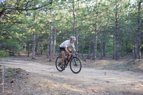 Fototapeta Naklejka Na Ścianę i Meble -  Young athlete riding on his professional mountain or cyclocross bike in the forest 