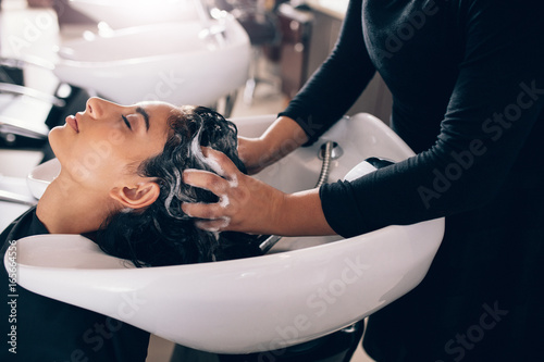 Fotografiet Woman getting hair shampooed at salon