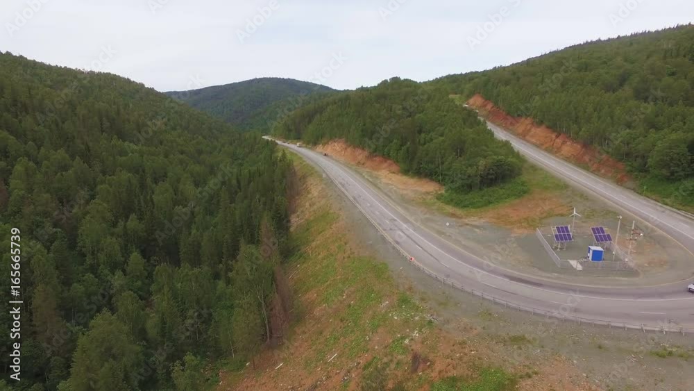 AERIAL: The perfect view of the mountain landscape. Including slowly passing cars and semi-truck through the serpentine around the solar station. Forest, dirt,rocks, nature. AERIAL: The perfect view of the mountain landscape. Including slowly passing cars and semi-truck through the serpentine around the solar station. Forest, dirt,rocks, nature.